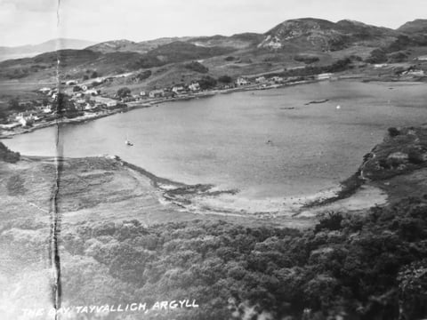 Aerial black and white photograph of Tavallich, Argyll showing a coastal bay with forested hills and scattered buildings along the shoreline